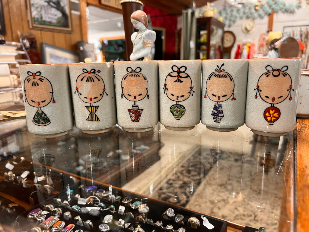Vintage Japanese sake cup set (6 cups) with crackle glaze and Kokeshi doll-style designs, signed on back