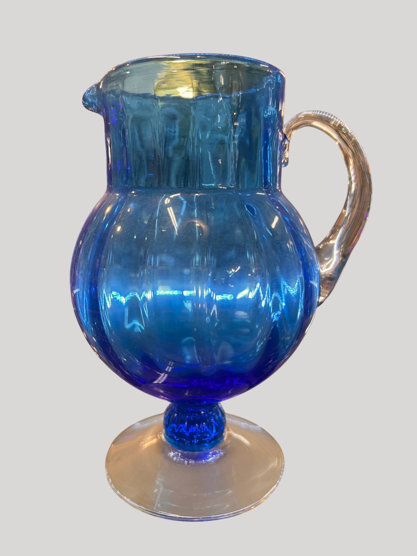 Hand-blown cobalt blue glass pitcher with clear handle and foot, showing pontil mark. Likely studio glass, mid–20th century or later