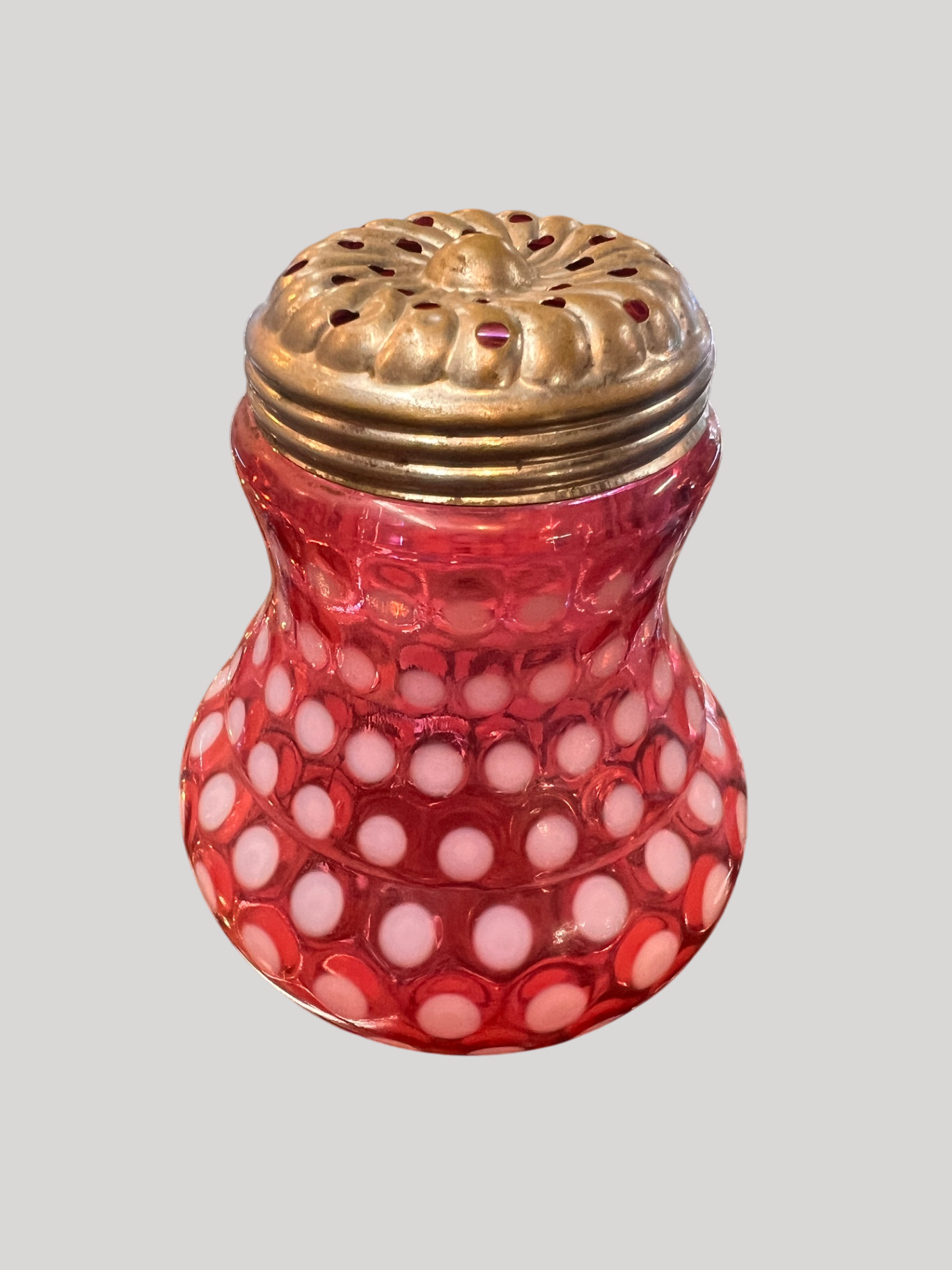 This is a cranberry opalescent coinspot (or inverted thumbprint) glass jar with a metal flower frog lid (used to arrange flowers)