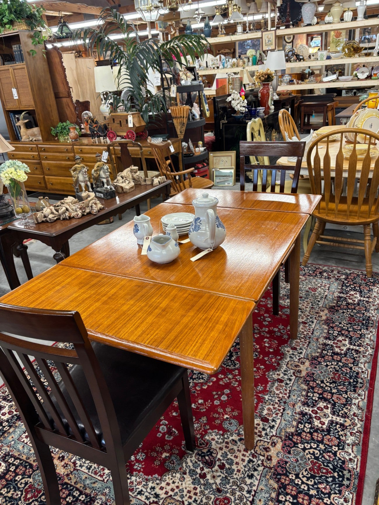  Danish Mid-Century Modern extendable dining table, typically made of teak or with a teak veneer finish. It is a compact, square-form