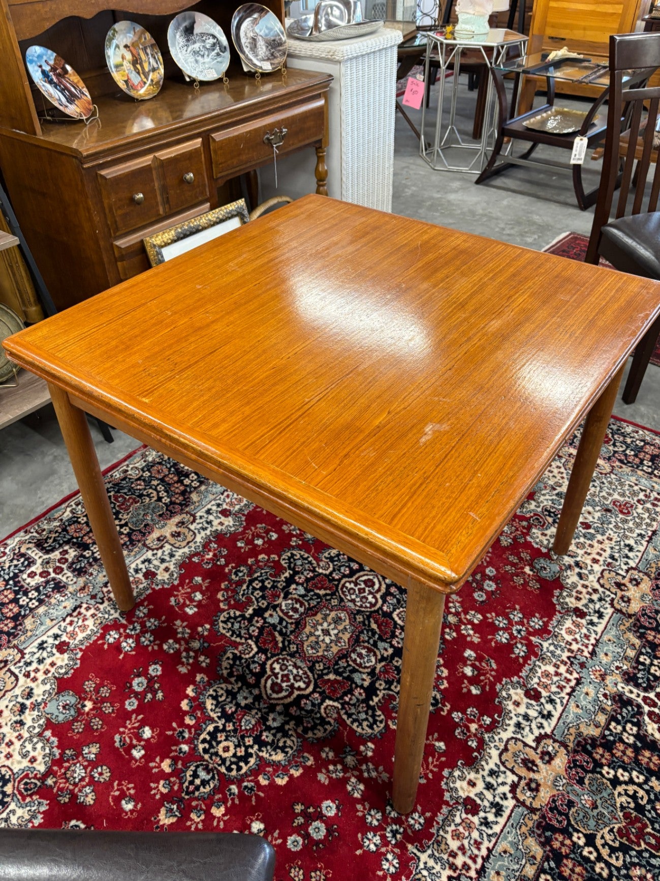  Danish Mid-Century Modern extendable dining table, typically made of teak or with a teak veneer finish. It is a compact, square-form