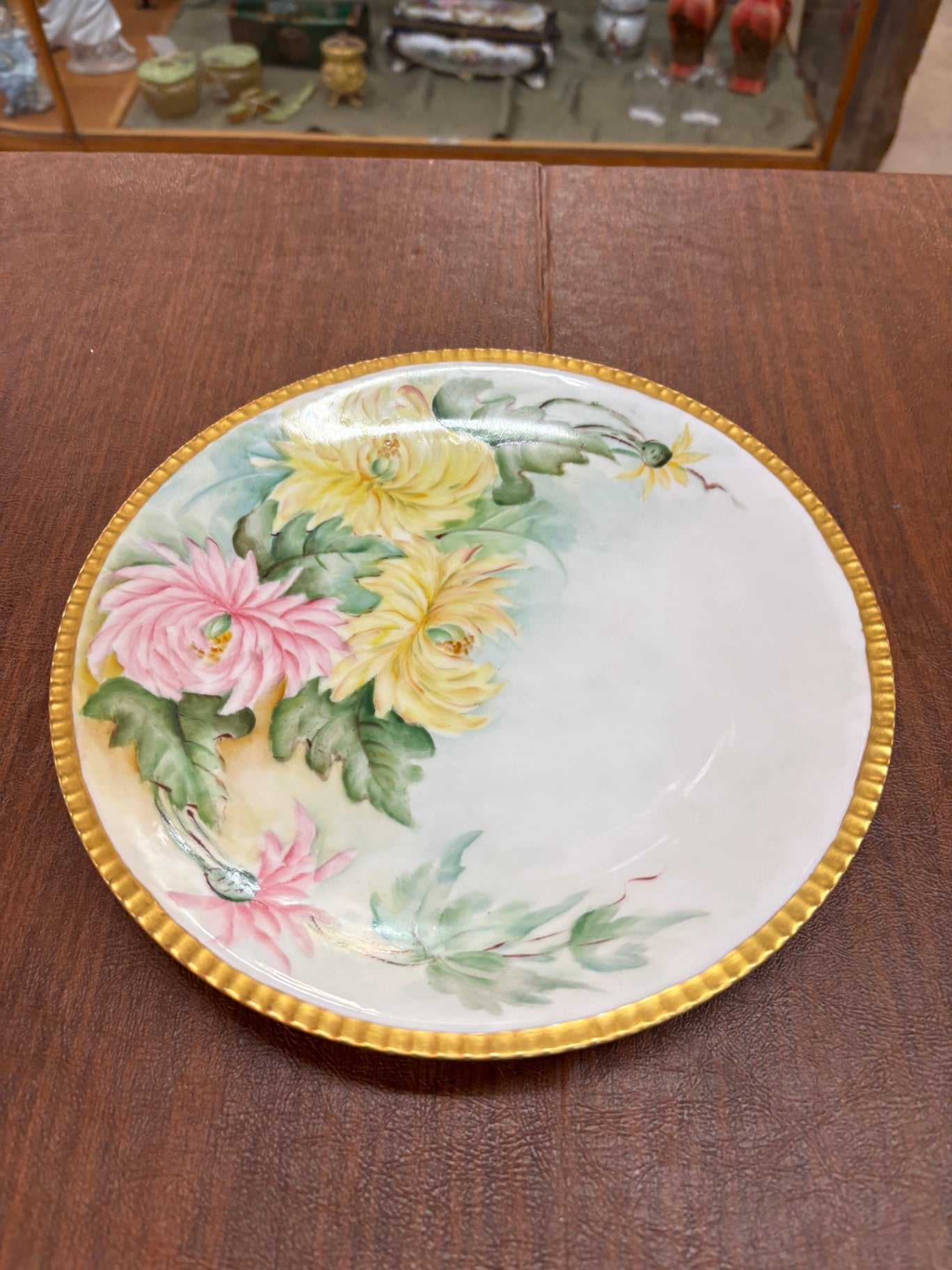  antique hand-painted porcelain cabinet plate featuring a floral chrysanthemum pattern and a gilded edge.
