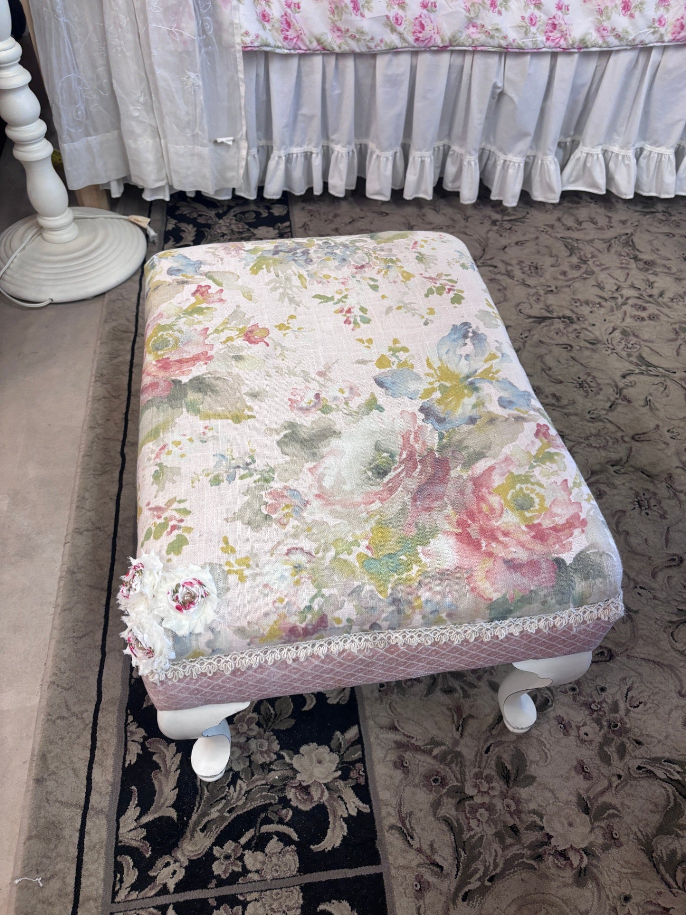 Footstool featuring a floral tapestry pattern