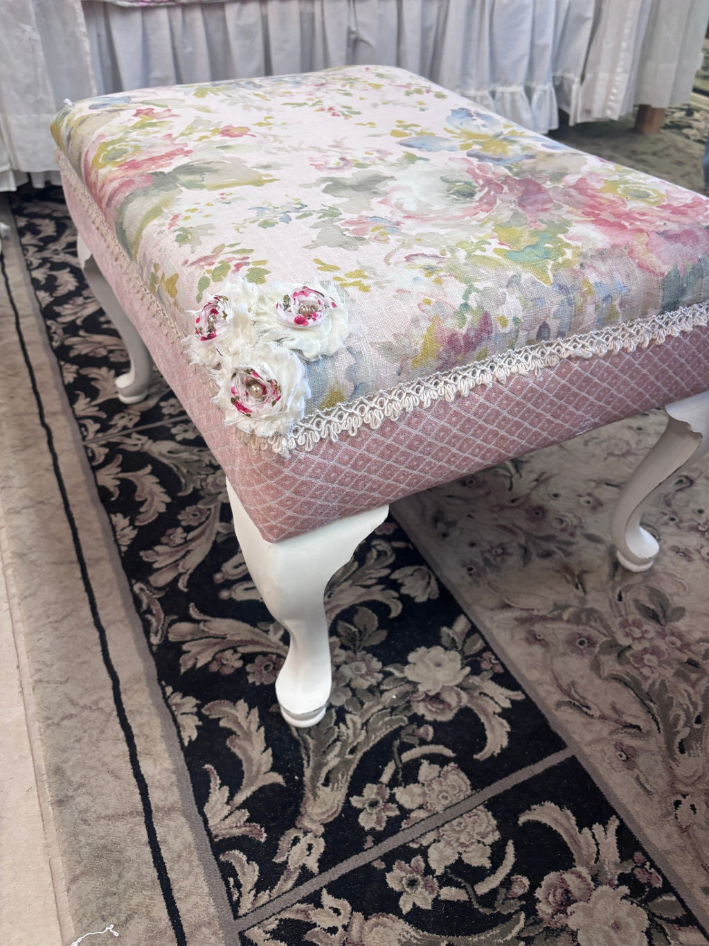Footstool featuring a floral tapestry pattern