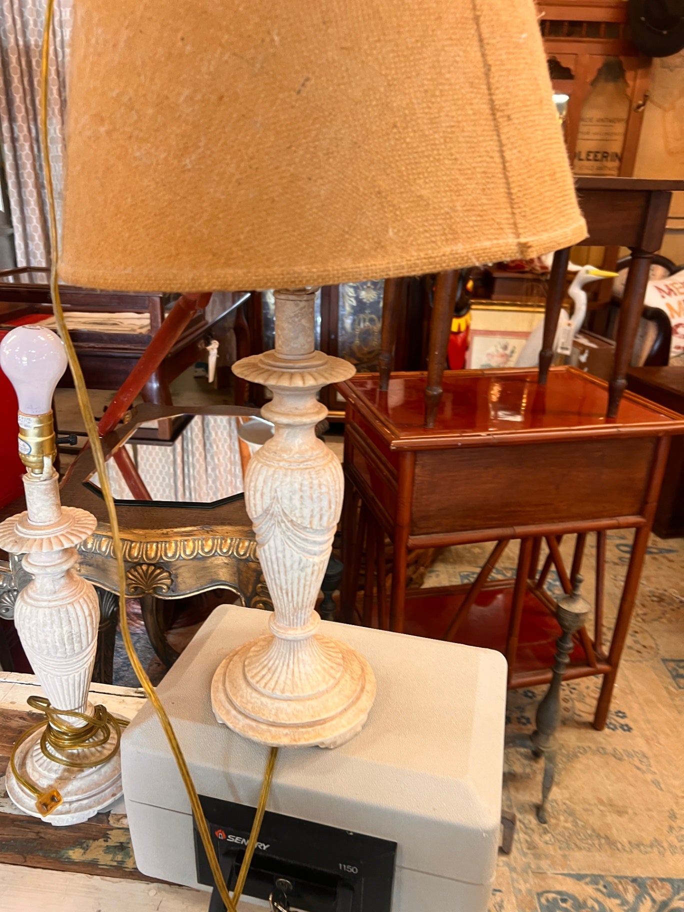 This vintage white table lamp features a Neoclassical urn-style base with carved details