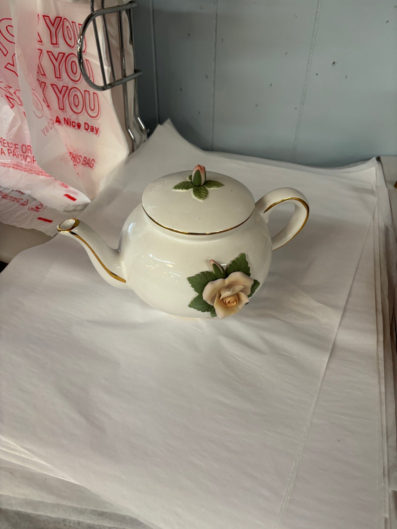 This is a white porcelain Teleflora teapot decorated with a 3D pink rose and gold trim.