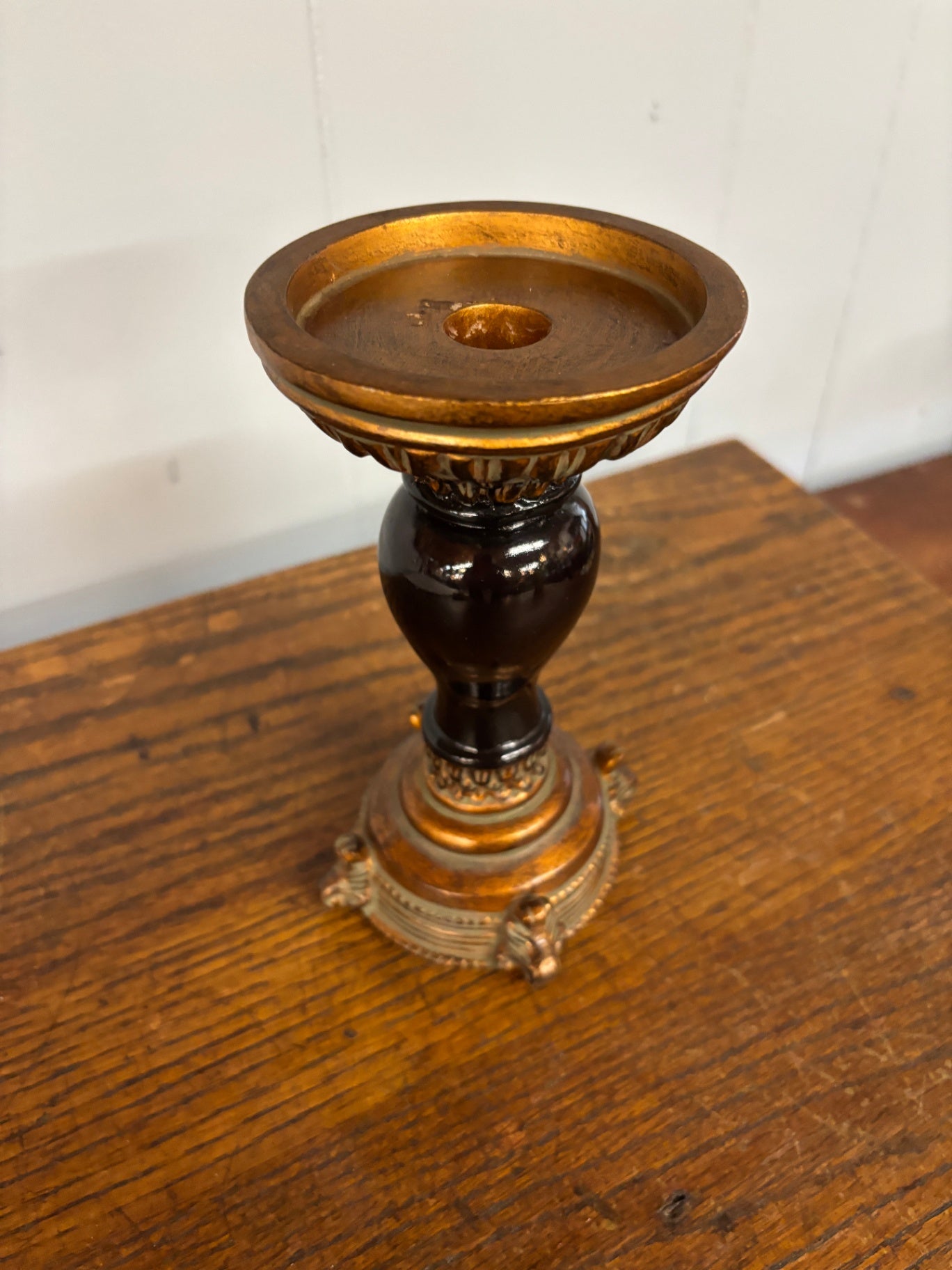 This Luxiva candlestick features a dark brown center with antique gold accents and a footed base