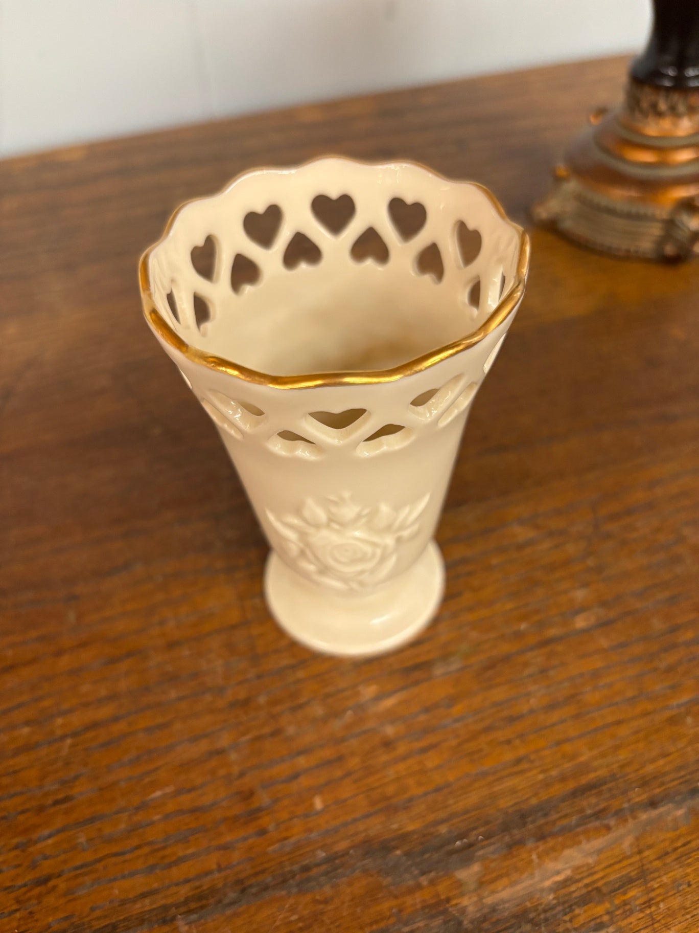 This Lenox China Heart Posy vase features intricate heart-shaped cutouts along the rim, embellished with a 24k gold trim