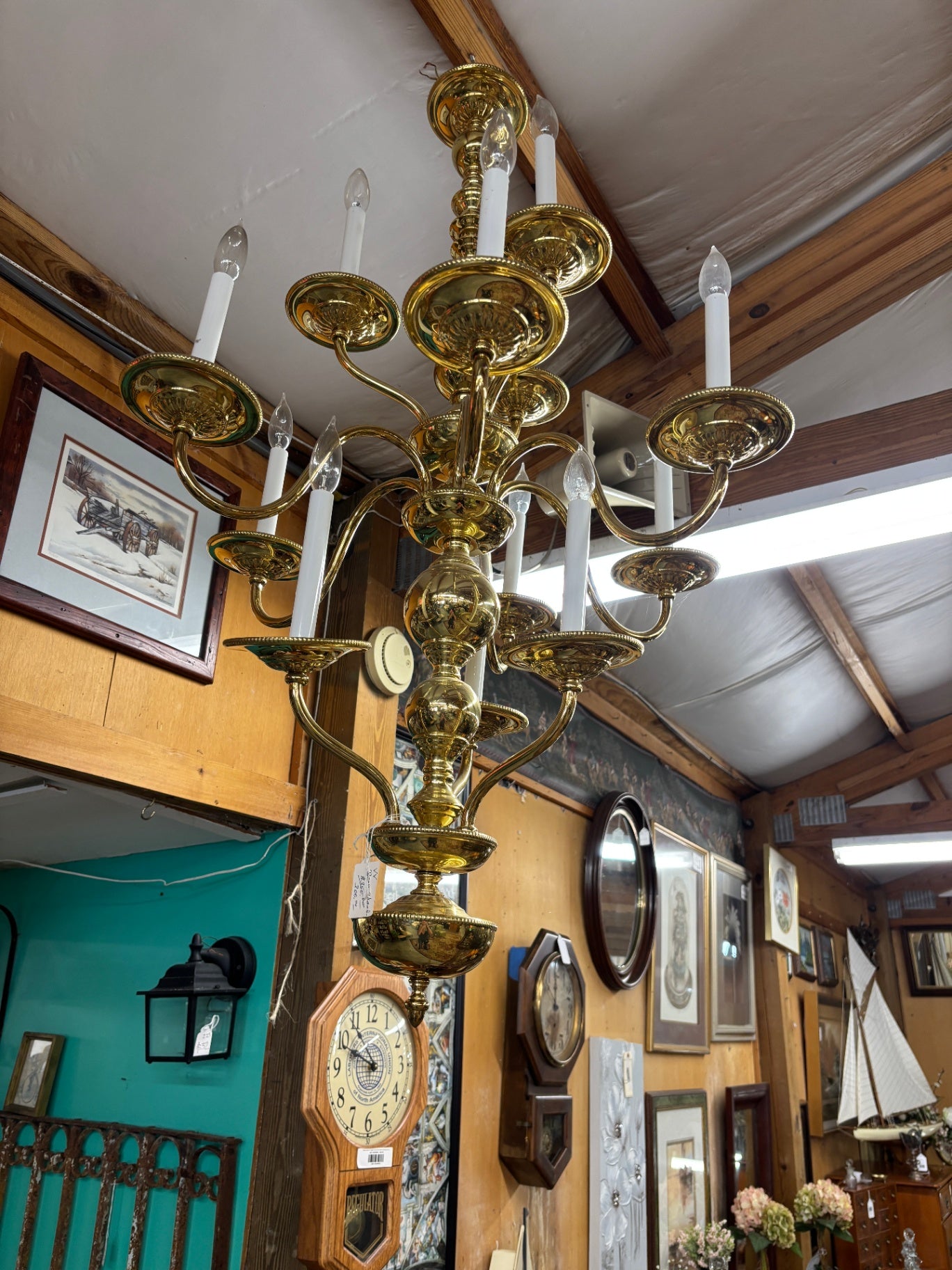 This Chapman solid brass two-tier 12-light chandelier features a prominent central orb and ornate candle holders