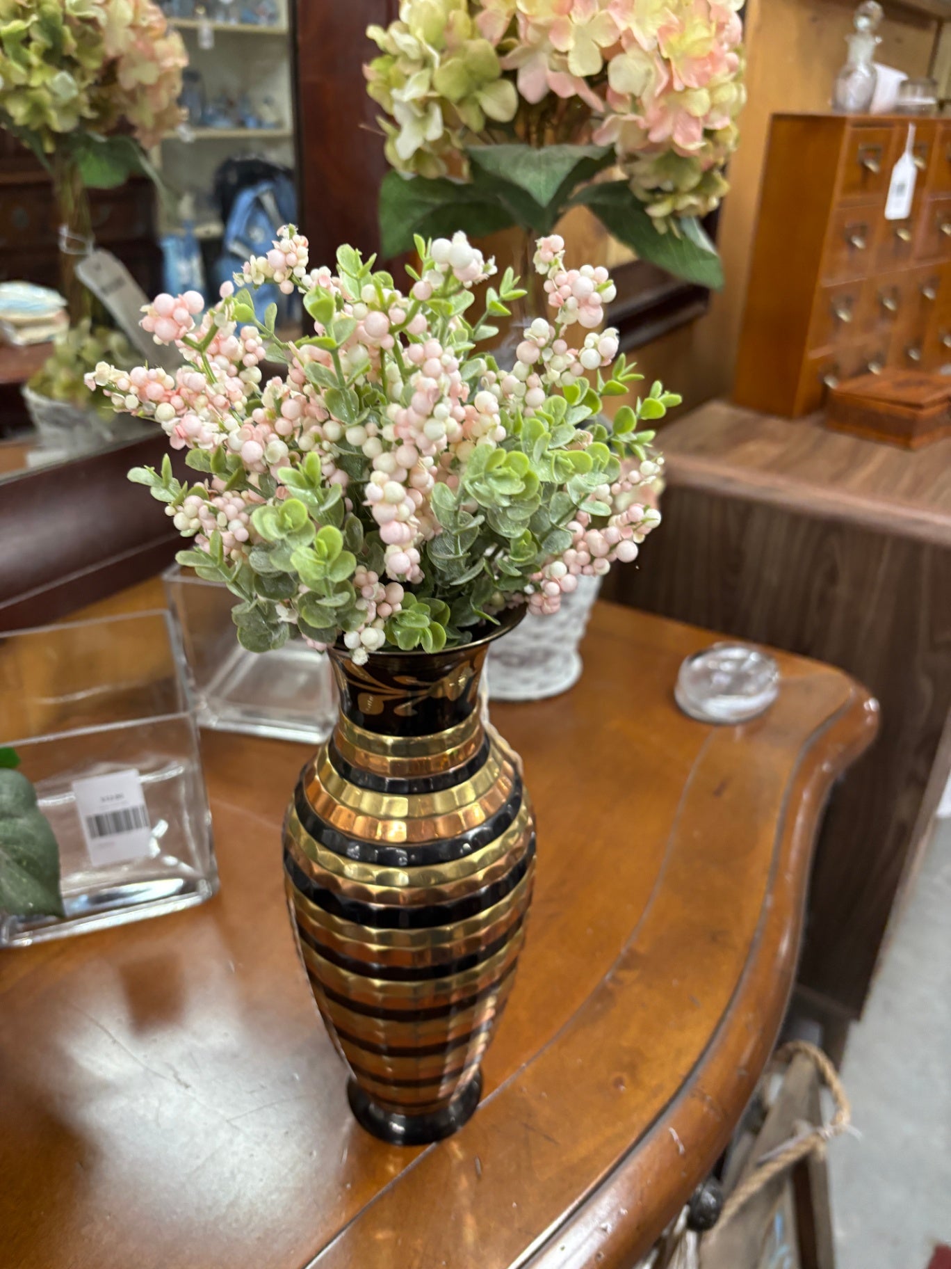 This black and gold striped vase features a ribbed texture and is similar in style to vintage Indian brass decorative pieces