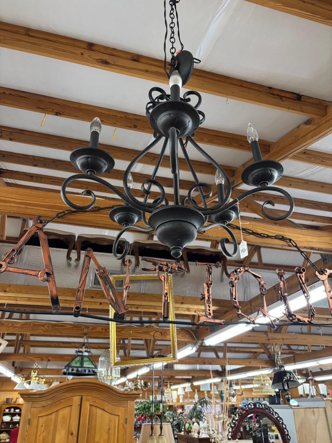 This black, wrought iron chandelier features a classic Spanish-style scroll design with five lights
