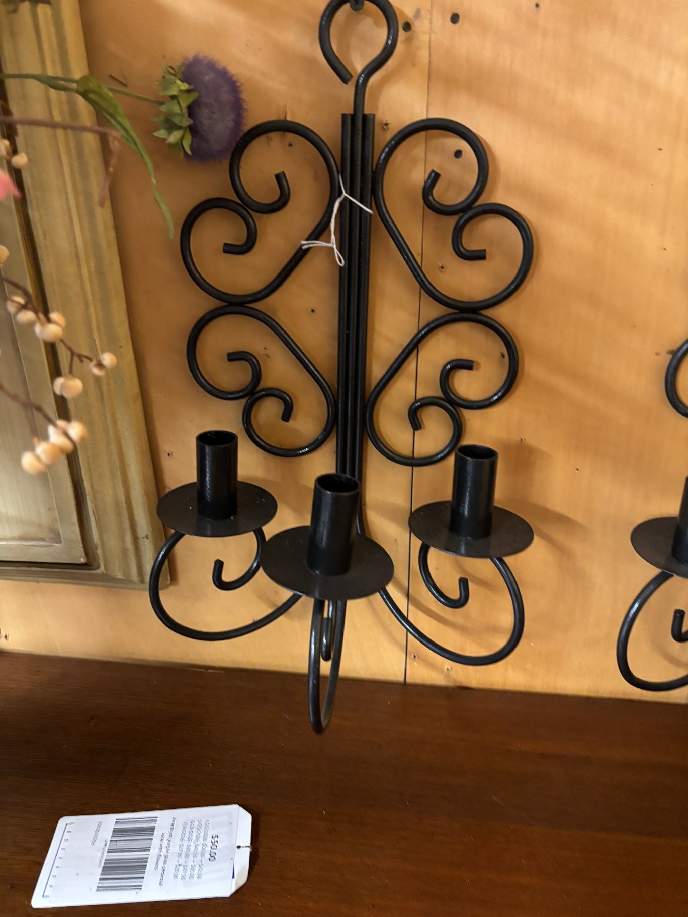 This is a vintage French country wrought iron triple candle wall sconce featuring decorative black scrollwork.