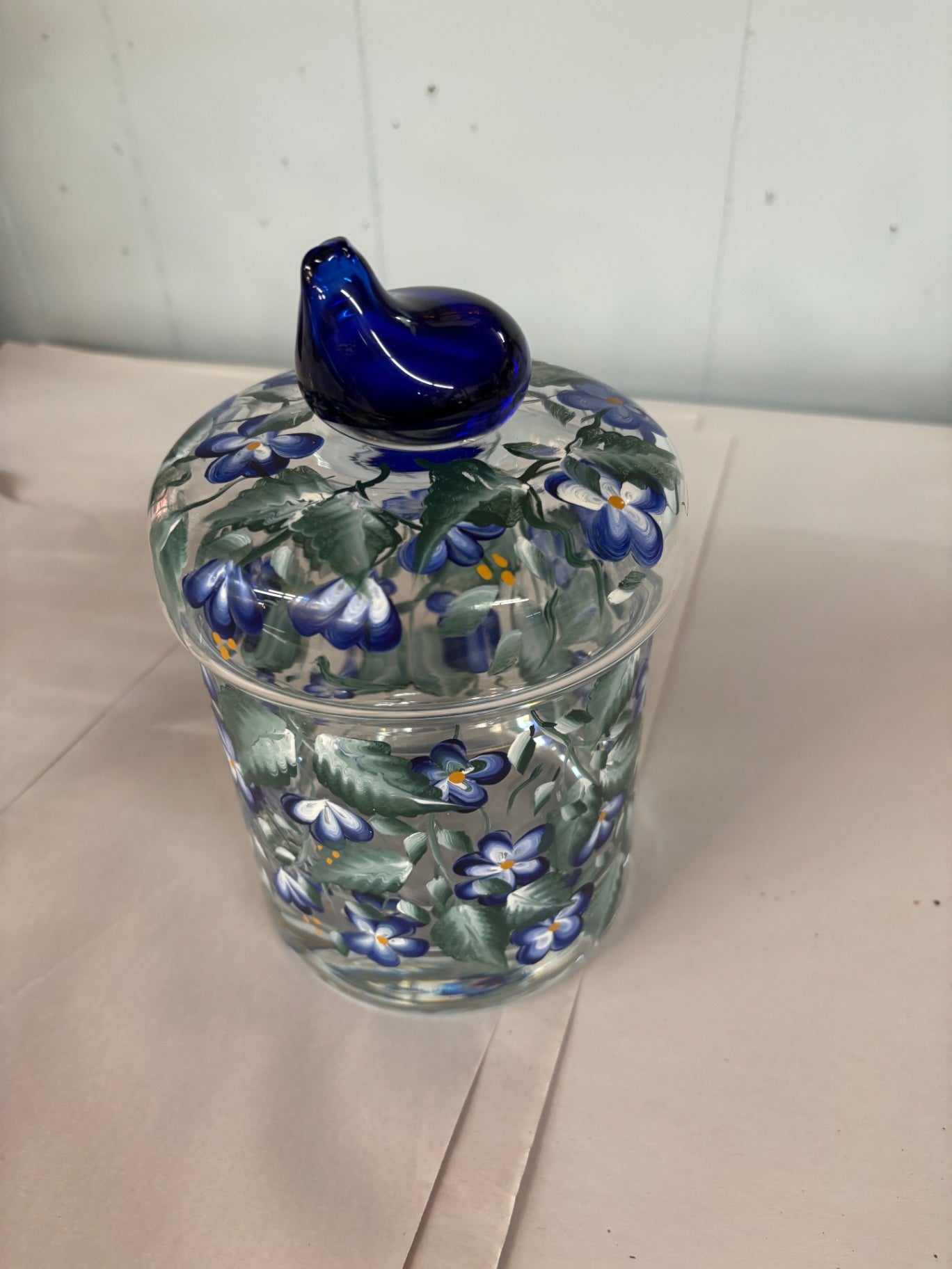  hand-painted glass jar features a distinctive blue bird-shaped handle on the lid.