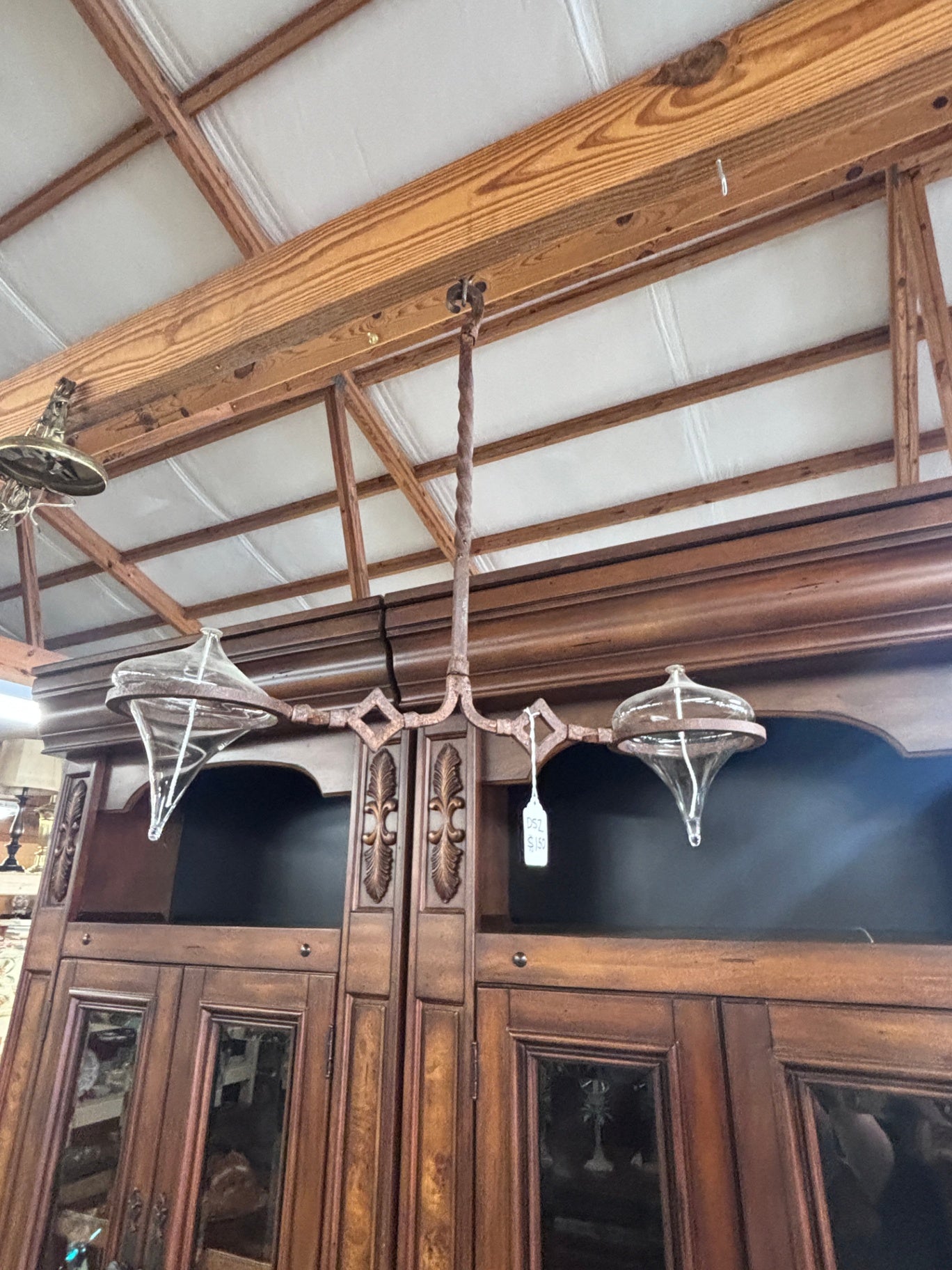  Vintage chandelier distinct wrought iron frame and two cone-shaped glass shades.