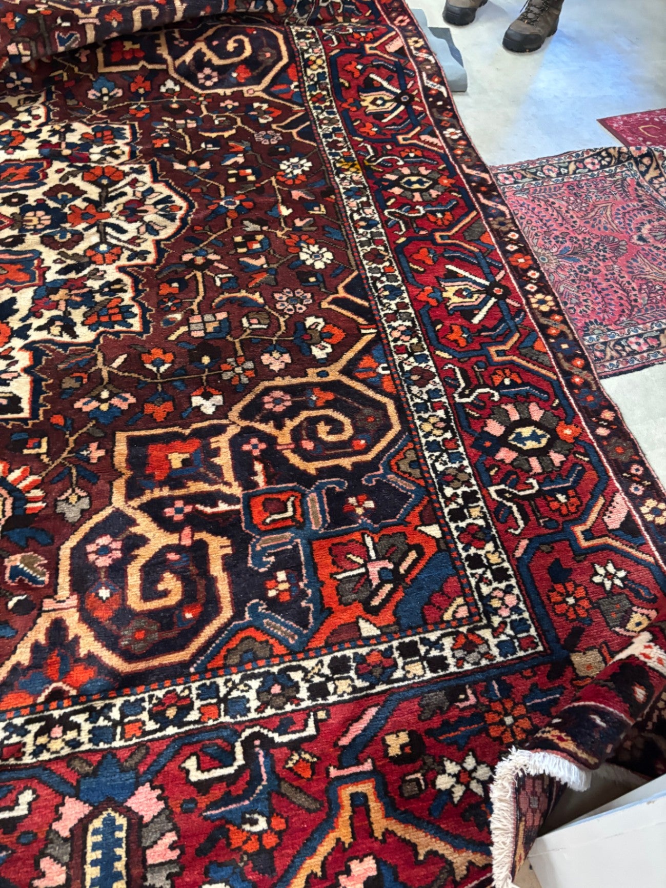  Hand-knotted tribal rug with a bold geometric center medallion set against a rich red and rust field