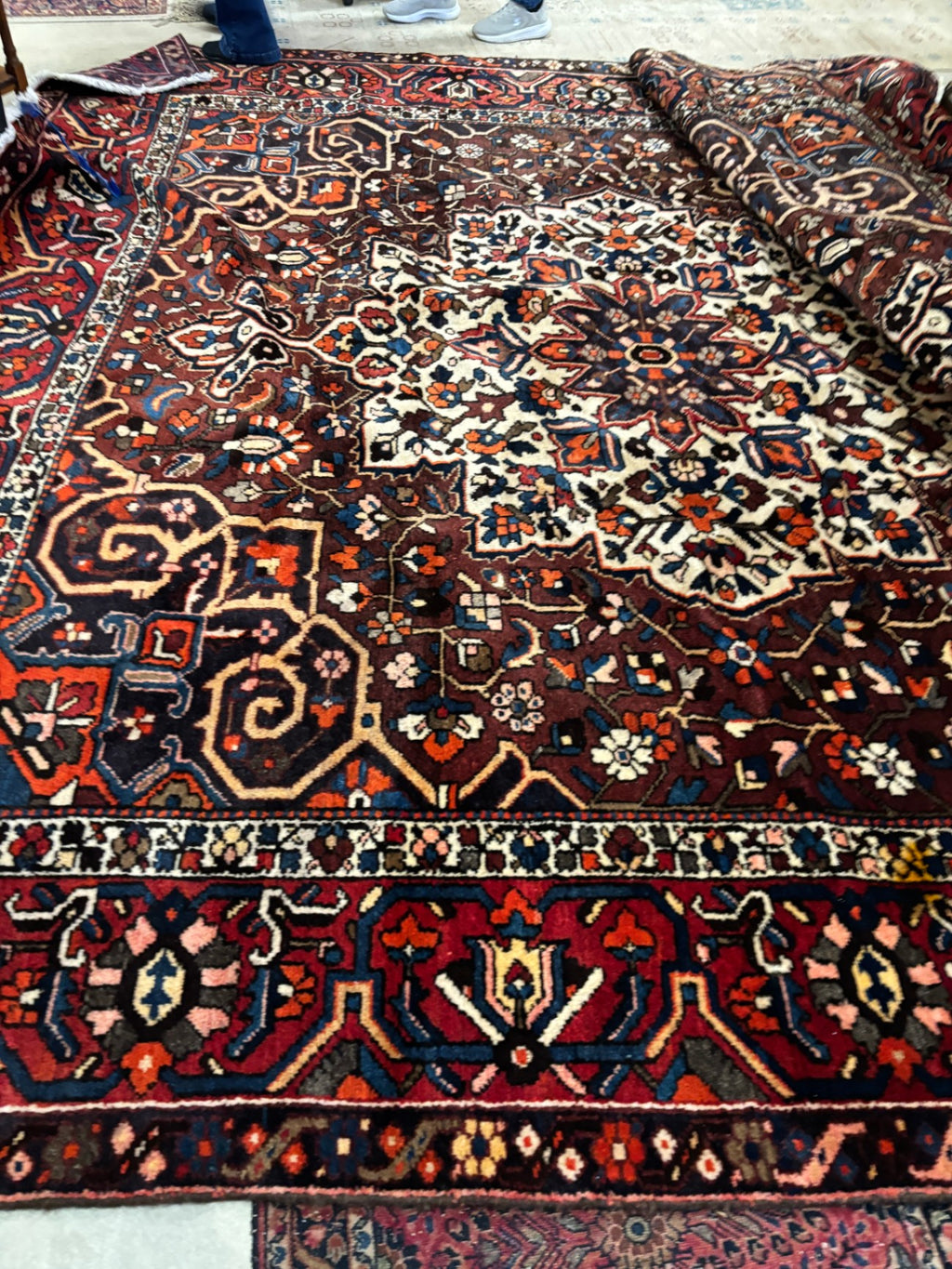  Hand-knotted tribal rug with a bold geometric center medallion set against a rich red and rust field