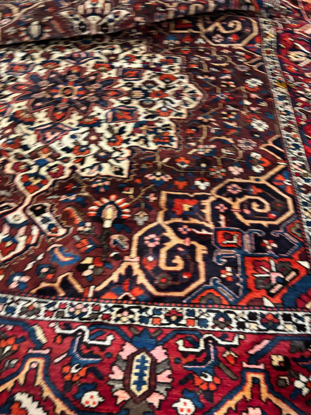  Hand-knotted tribal rug with a bold geometric center medallion set against a rich red and rust field