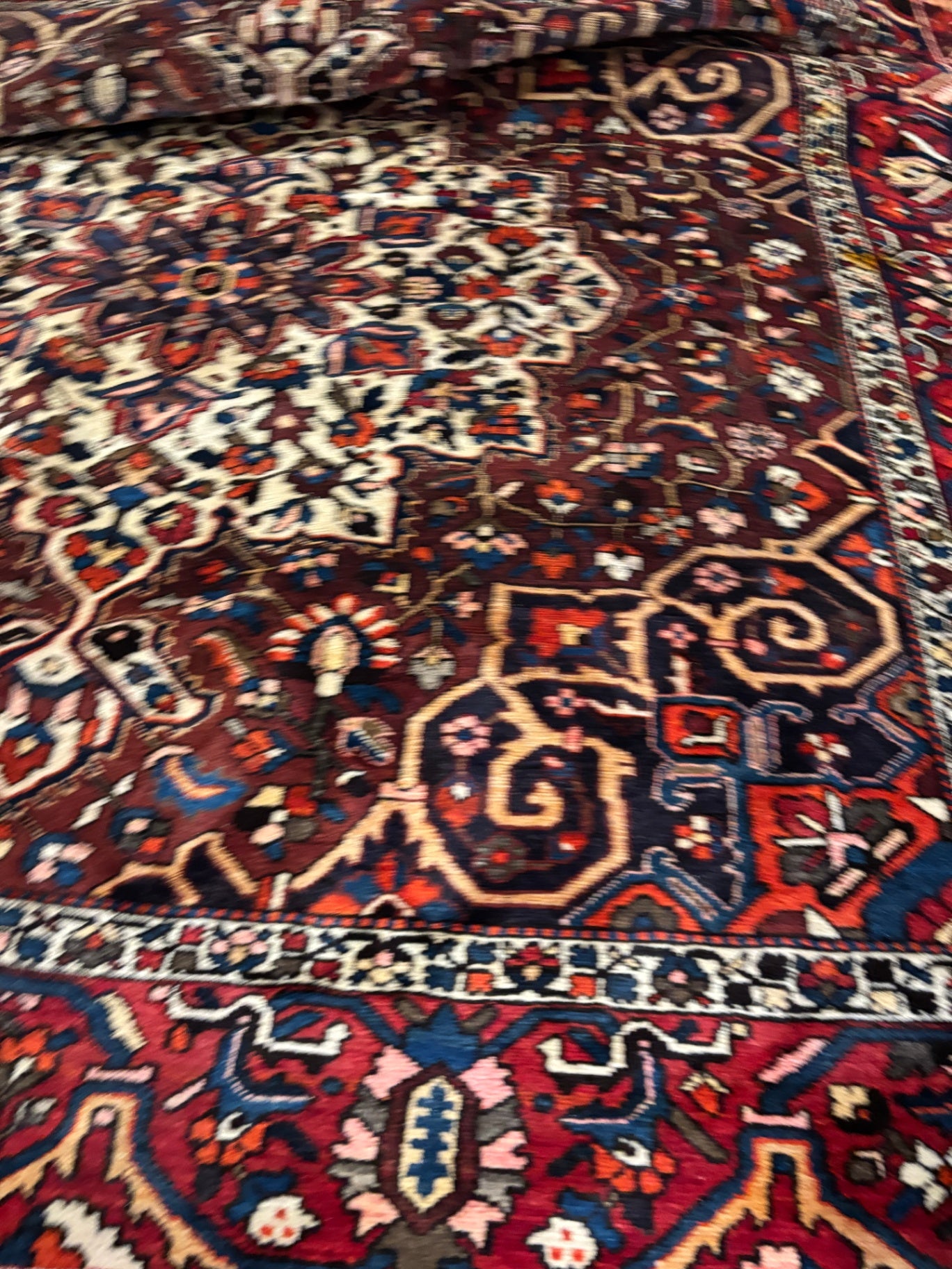  Hand-knotted tribal rug with a bold geometric center medallion set against a rich red and rust field