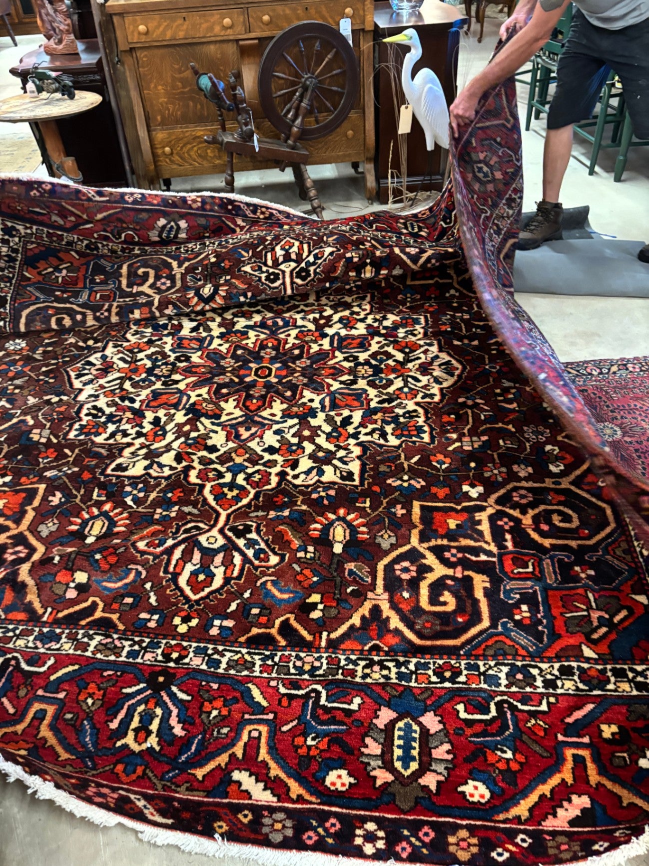  Hand-knotted tribal rug with a bold geometric center medallion set against a rich red and rust field