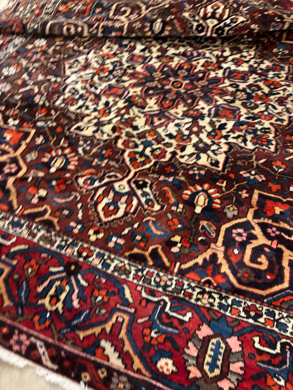  Hand-knotted tribal rug with a bold geometric center medallion set against a rich red and rust field