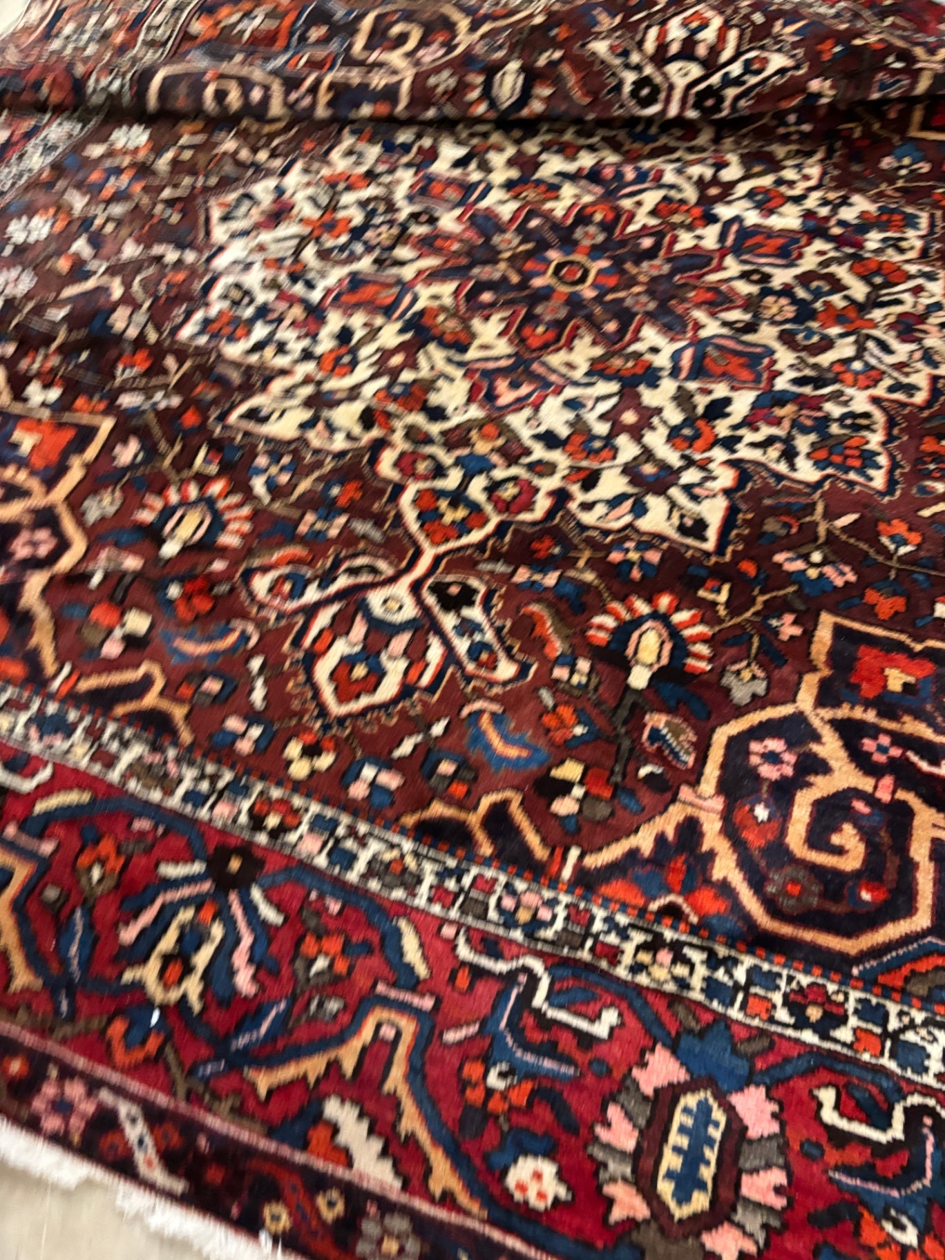  Hand-knotted tribal rug with a bold geometric center medallion set against a rich red and rust field