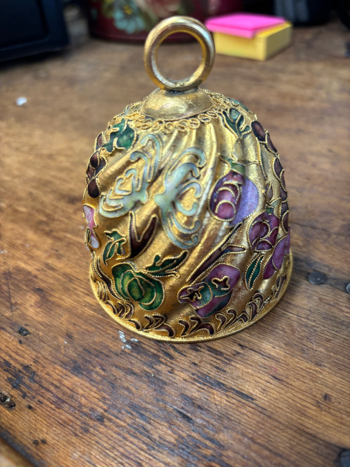 Enamel bell ornament featuring multicolored floral and foliage patterns
