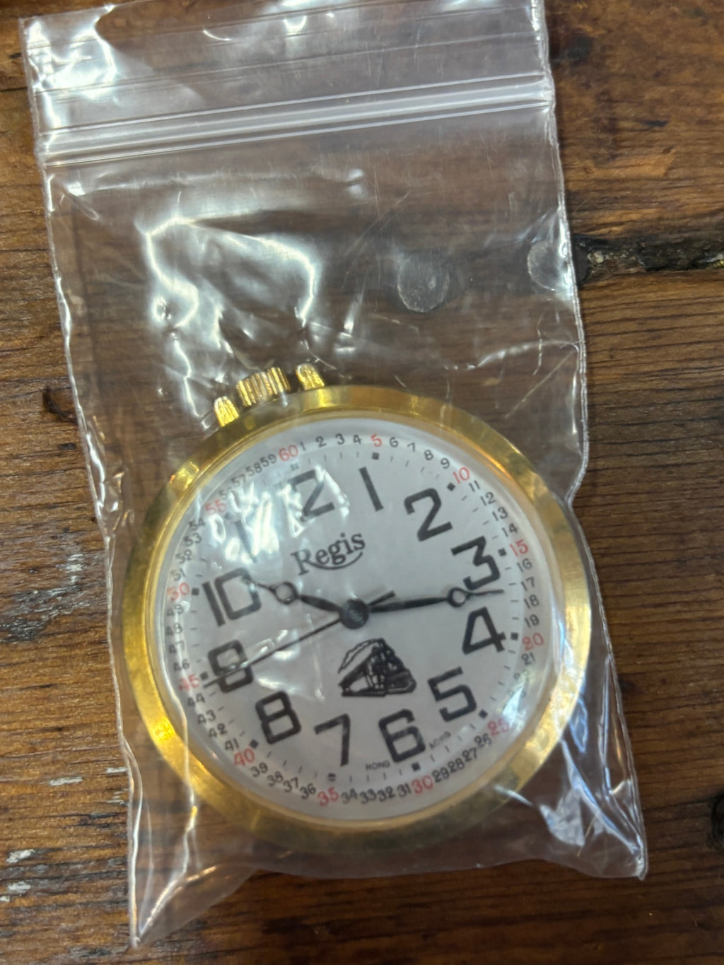 Comemorative gold-tone pocket watch featuring an embossed steam locomotive on the cover