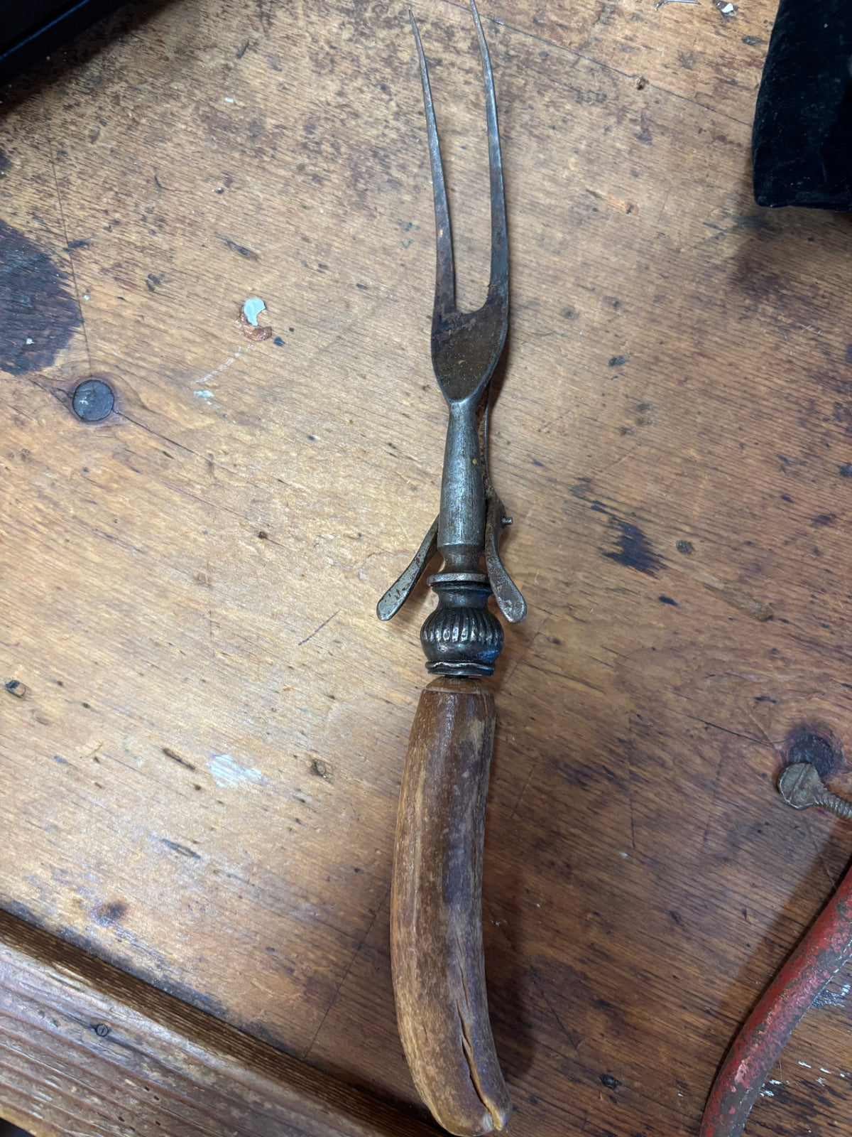 Antique meat carving fork with a stag horn or antler handle and a retractable or hinged spring guard