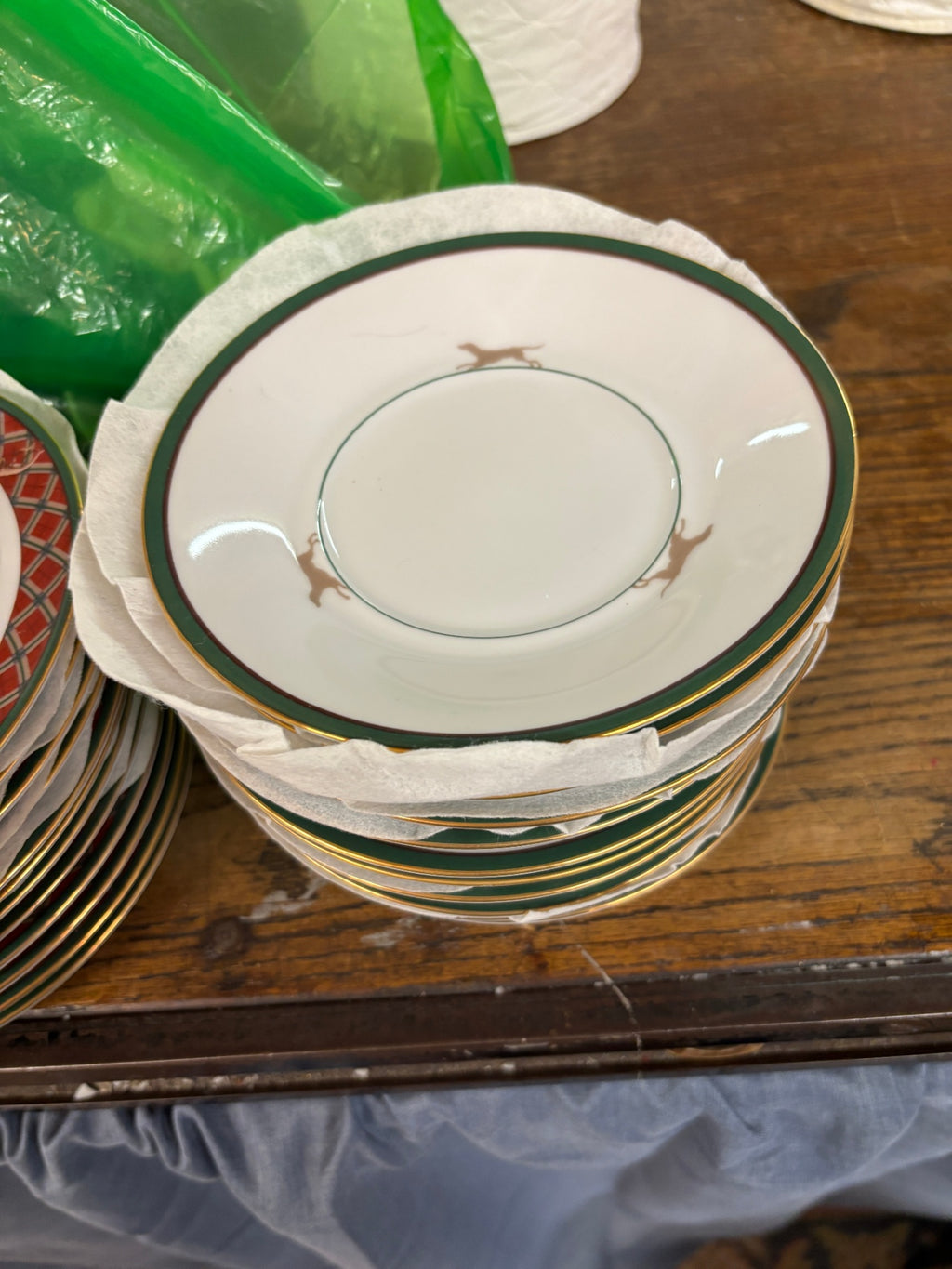 White ceramic saucer with a dark green border and gold trim from the Noritake Royal Hunt