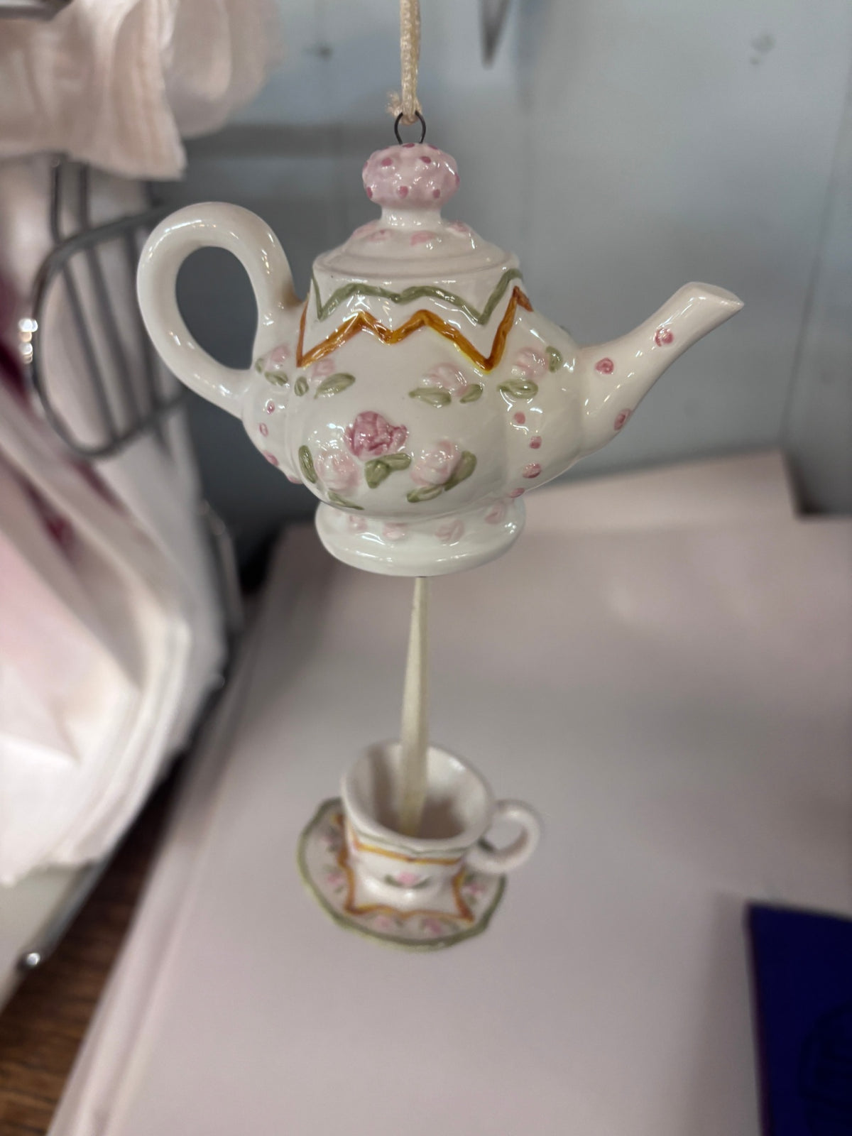 Vintage porcelain hanging Christmas tree ornament featuring a white teapot decorated with pink roses and green leaves
