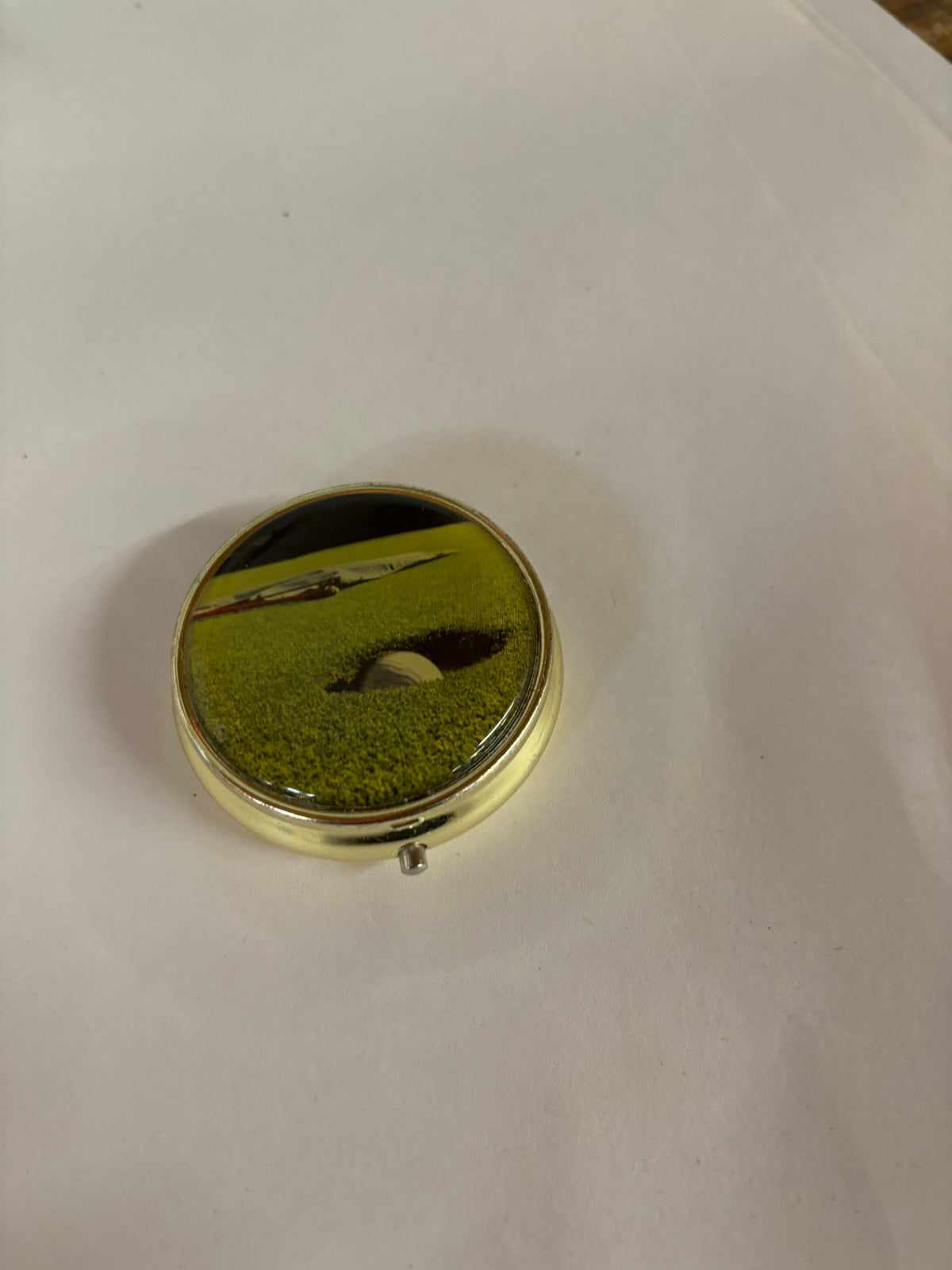 Golf-Themed Round Gold-Tone Pill Box with Golf Ball & Fairway Design