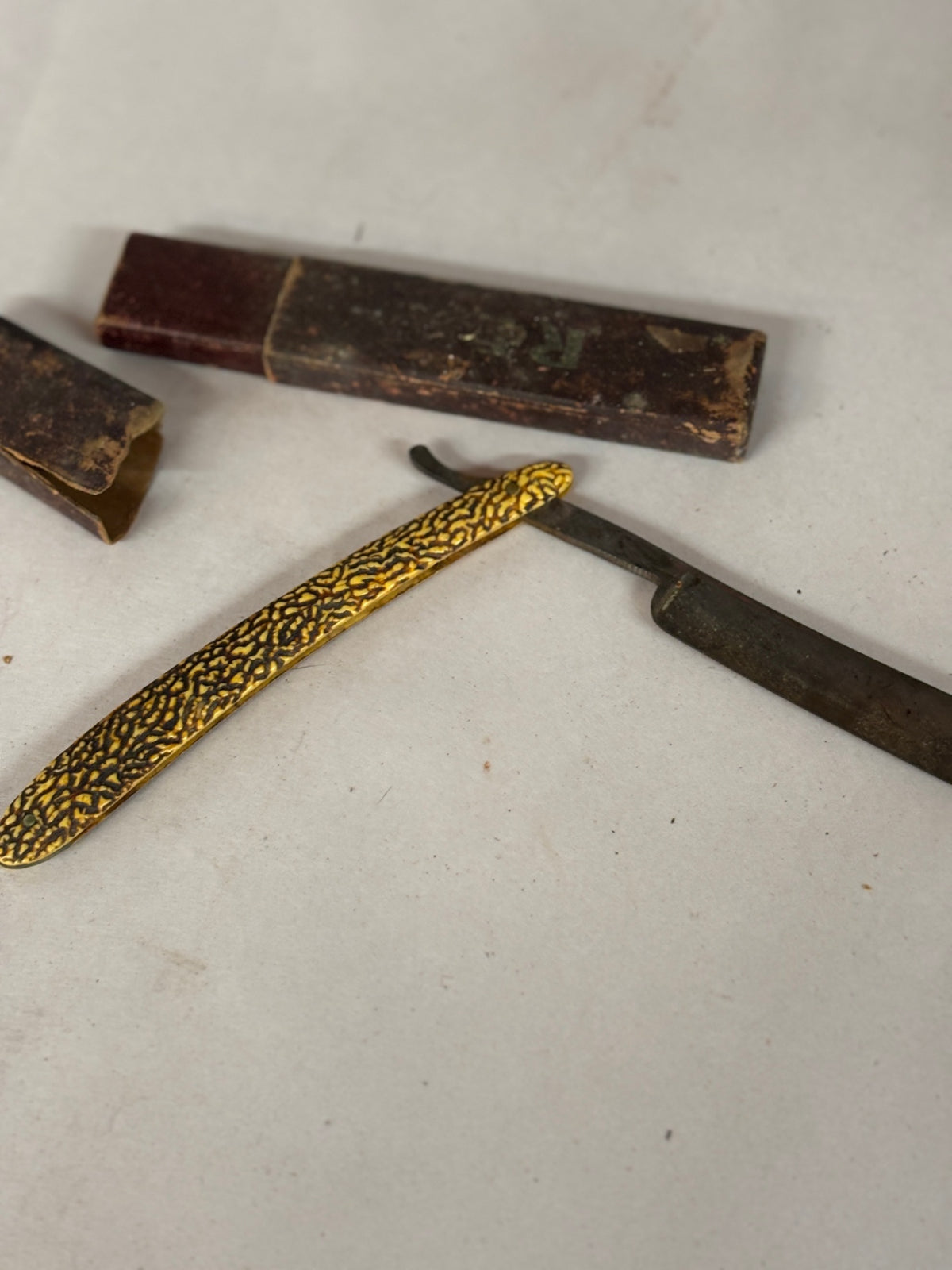 Vintage Straight Razor with Ornate Gold-Tone Textured Handle and Original Case