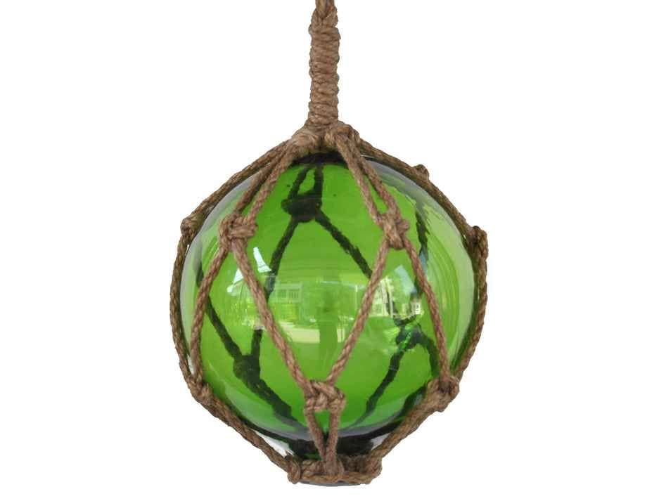 Green glass ball buoy with rope on a white background